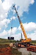 A 150USt capacity Grove RT9150E rough terrain crane lifts a component.